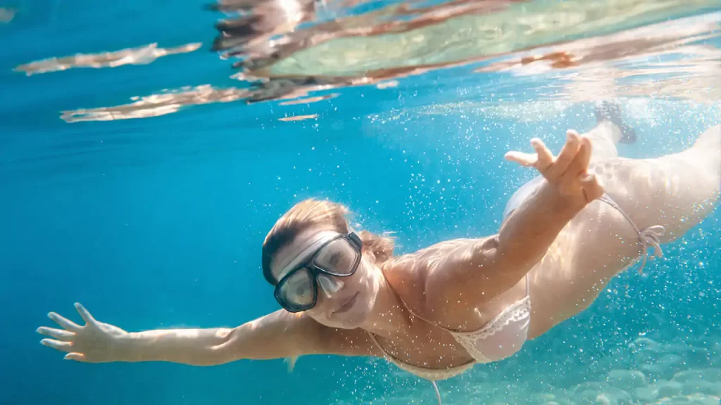 beautiful  woman underwater snorkeling in the clear blue ocean of lombok island