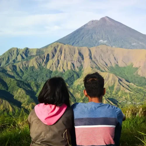 sepasang kekasih menikmati pemandangan bukit nanggi sembalun dan rinjani